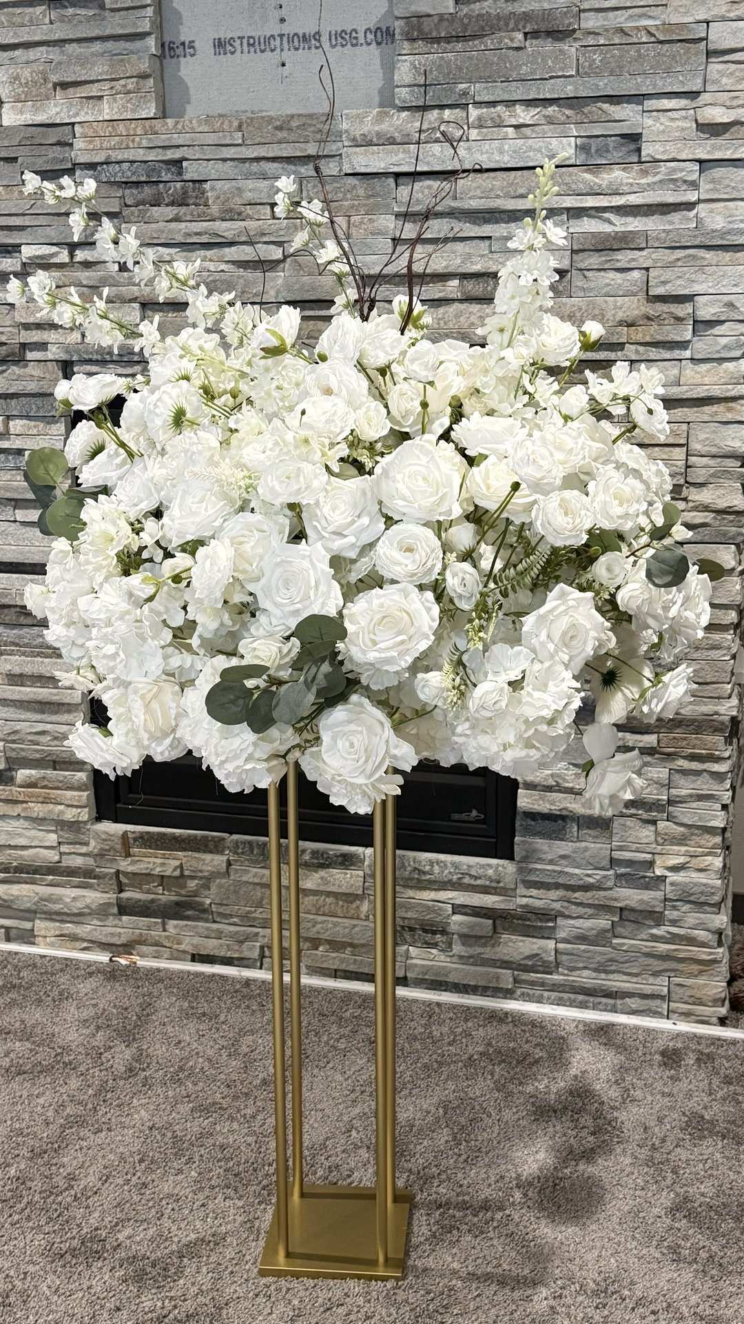 White floral arrangement on gold geometric stand